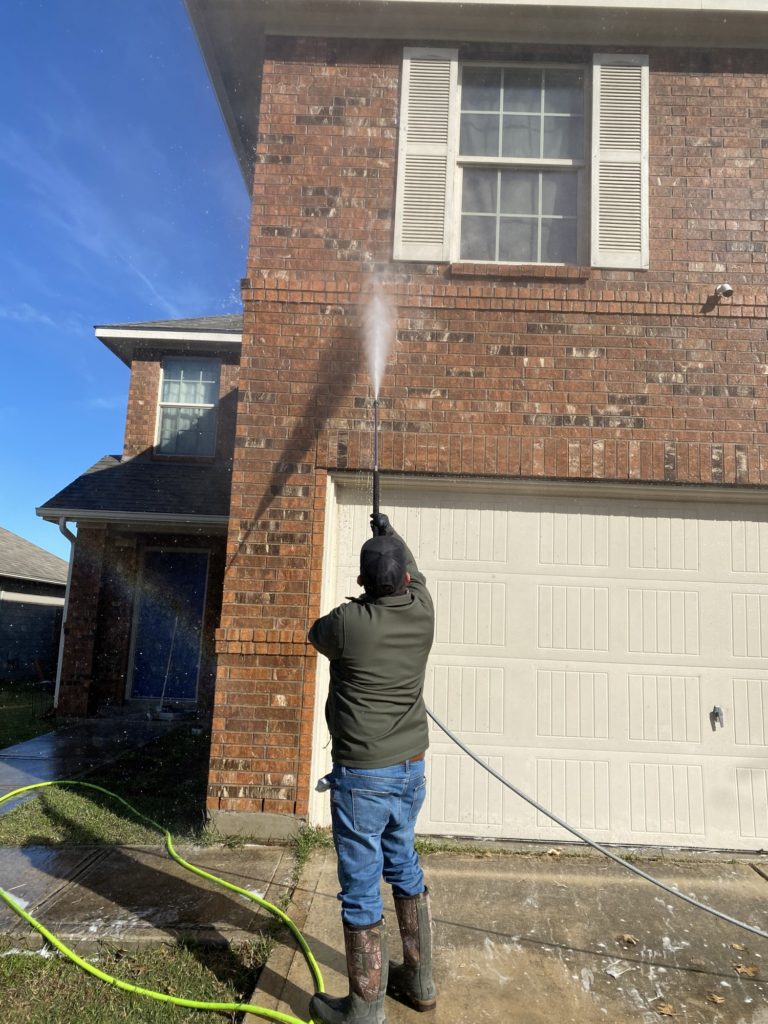 Josh Beyer soft-washes the exterior brick of this 2 story home in San Antonio Texas