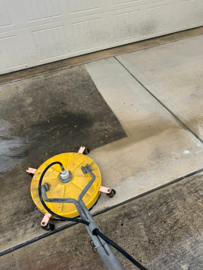 The Service Shown Is Pressure Washing Concrete Surfaces To Remove Dirt And Stains From The Driveway And Garage Area