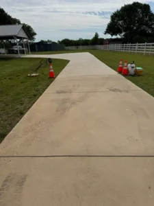 The Service Involves Pressure Washing A Concrete Driveway To Remove Dirt And Tire Marks For A Clean Surface