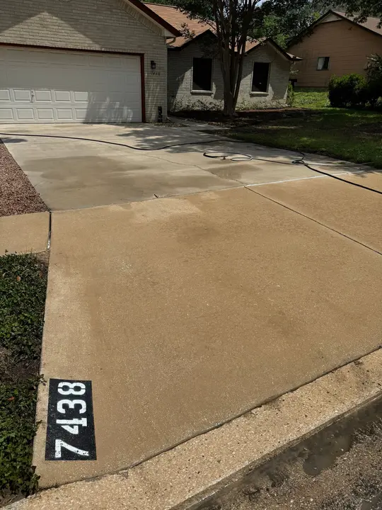The Surface Is Being Pressure Washed To Remove Dirt And Grime From The Driveway And Sidewalk Areas