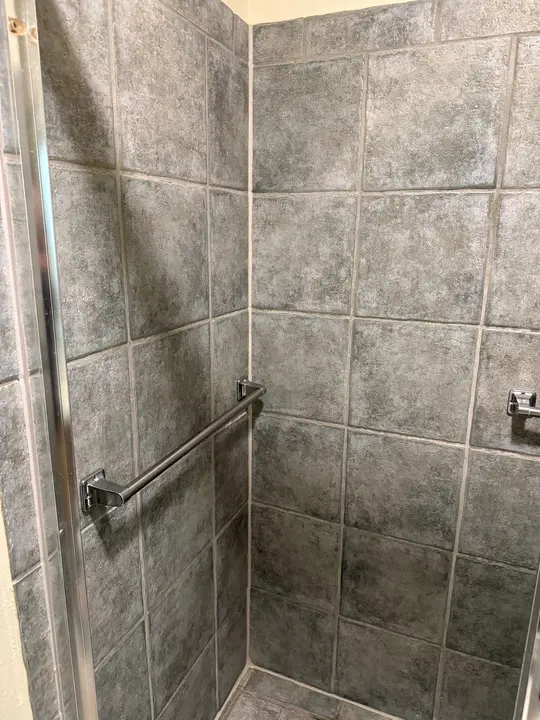 The Service Being Done Is Deep Cleaning Of Tile Surfaces In A Shower To Remove Grime And Stains